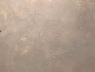 Beige verputzte Wand mit texturierter Oberfläche.
